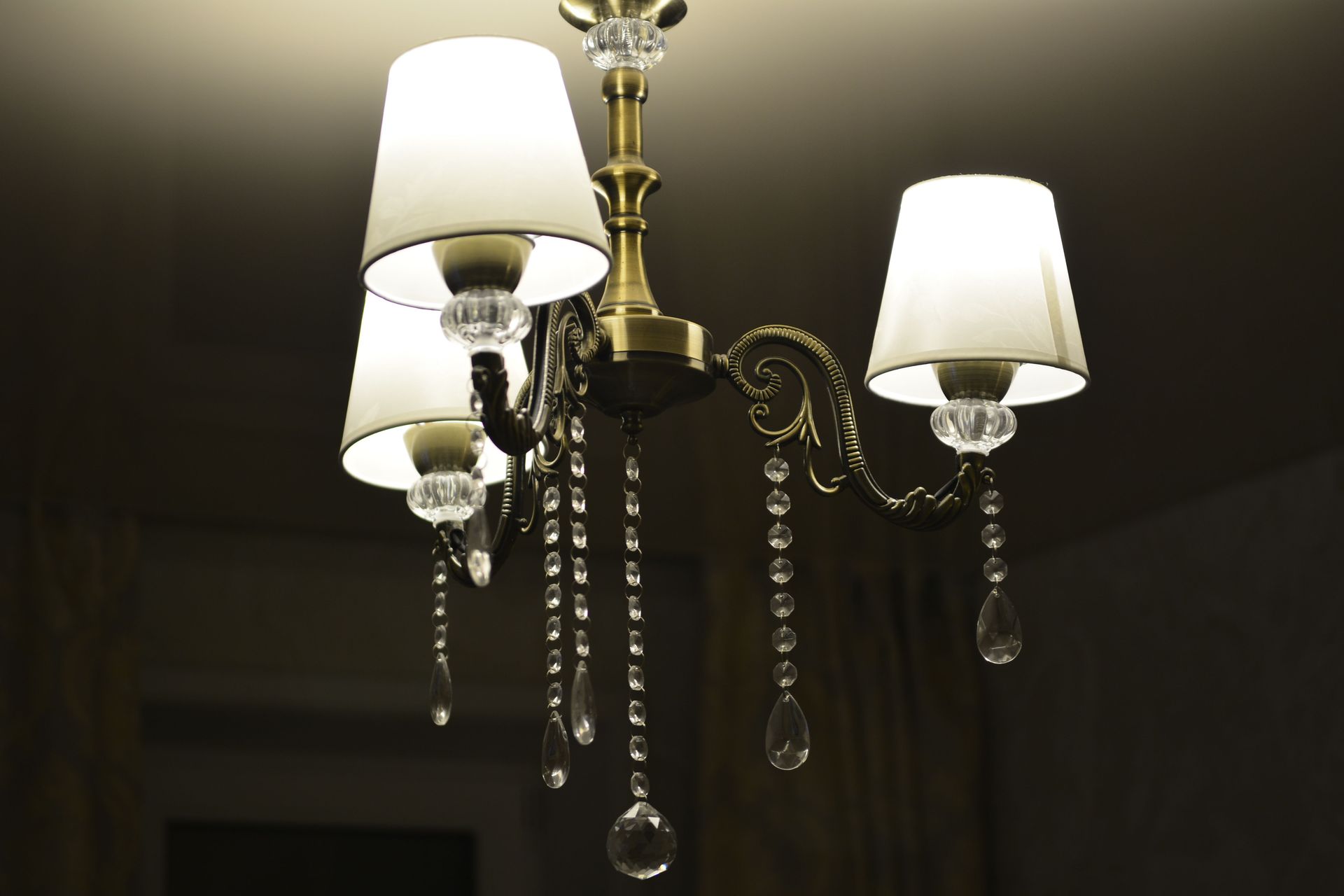 Close-up of an illuminated brass chandelier with crystal accents, ideal for interior decor themes.